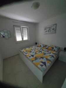 una camera da letto con un letto con un piumone colorato di Apartmani Matko a Nin