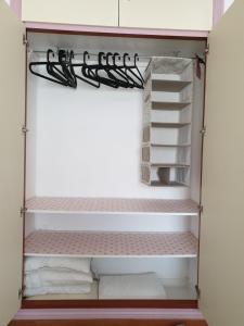 a walk in closet with white and pinkorganized at Sol y Luz in Isla del Moral