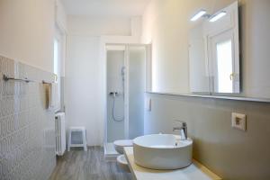 a white bathroom with a sink and a mirror at Bellagio Villas in Lezzeno