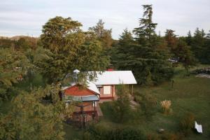 uma pequena casa vermelha no meio de uma floresta em Via Pringles Cabañas Boutique em Sierra de la Ventana