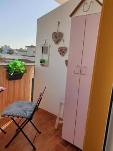 a room with a chair and a pink cabinet at Sol y Luz in Isla del Moral