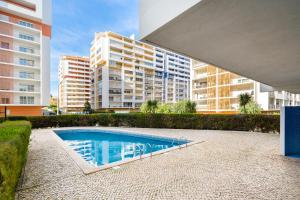 a swimming pool in front of some buildings at Praia da Rocha, 502, Charming Apartment, Air conditioning, Swimming Pool,Free WIFI, Faia by IG in Portimão