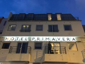 a building with a sign on the side of it at Hotel Primavera in Amadora