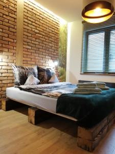 Cama en habitación con pared de ladrillo en Apartament na Mazurach, en Ełk