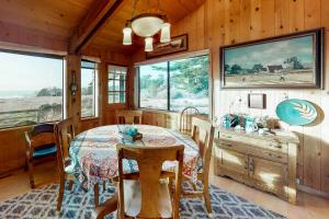 a dining room with a table and some windows at Thayer House in Sea Ranch