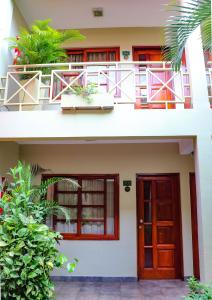 a house with a red door and a balcony at Hotel Jardin De Iguazu in Puerto Iguazú