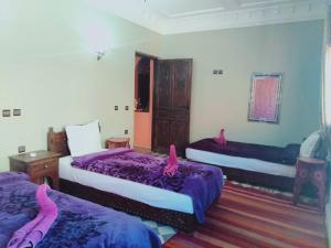 a bedroom with two beds with pink flamingos on them at Atlas Imoula in Imlil