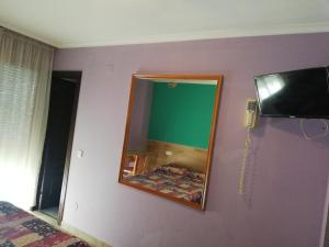 ein Schlafzimmer mit einem Spiegel und einem Telefon an der Wand in der Unterkunft Alojamientos ALBOR I in Gijón