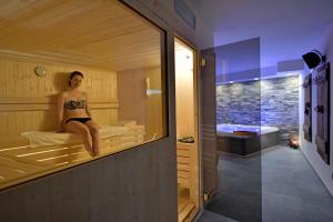 kobieta w bikini siedząca w saunie w obiekcie Alp Hotel Dolomiti w mieście Dimaro +33 zdjęcia