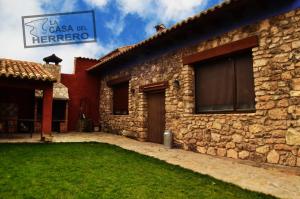 een stenen huis met een bord dat zegt casa tion herrero bij La Casa del Herrero in El Poyo