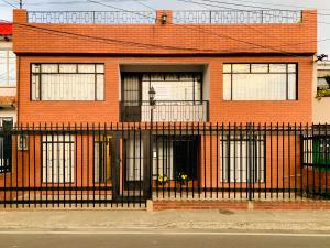 um edifício de tijolos vermelhos com uma cerca preta em Hospedaje Casa Bachué em Chía