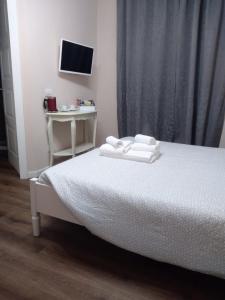 a bedroom with a bed and a desk and a television at Glam Resort Giulia in La Spezia
