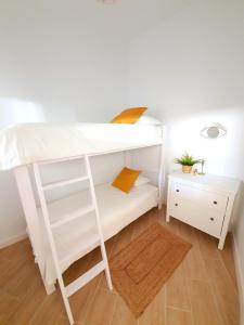 a white bunk bed with a ladder and a night stand at ALAYNA´S HOMES in Valle Gran Rey