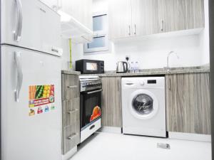 a kitchen with a washer and dryer in it at Warsan Star Residence - Home Stay in Dubai