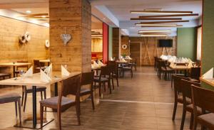 a dining room with tables and chairs in a restaurant at Penzion Lipa in Cífer
