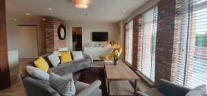 ein Wohnzimmer mit einem Sofa und einem Tisch in einem Zimmer in der Unterkunft Y Bwythyn in Holywell