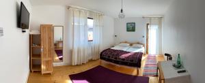 a bedroom with a bed and a room with a window at Poème in Sighetu Marmaţiei