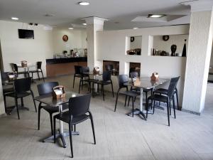um restaurante com mesas e cadeiras num quarto em Hotel Uzi Mar no Recife