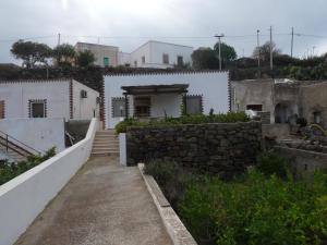 vistas a una casa con una pared de piedra en Dammuso Tracino, en Pantelleria