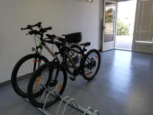 two bikes parked on a rack in a room at Apartments Romana in Postira