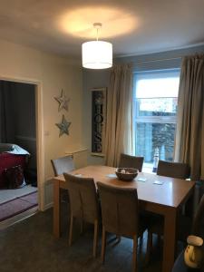 a dining room with a wooden table and chairs at Aelfor Cozy Cottage in Barmouth