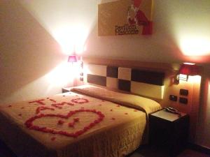 a room with a bed with a heart drawn on it at Hotel Visagi in Pompei
