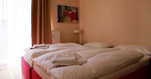 a bed with white sheets and towels on it at Hansa Apartments Hamburg in Hamburg