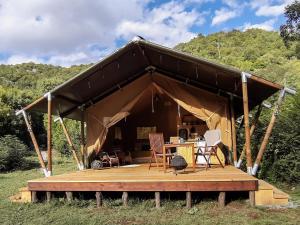 a tent with a table and chairs on a deck at Hoopoe Glamping in Virpazar