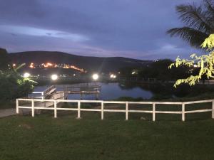 uma vista para um rio à noite com uma cerca em Flat 4 Suites Hotel Portal Gravata em Gravatá