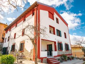 een rood-wit gebouw met een boom ervoor bij le Rose di santina in Mamoiada