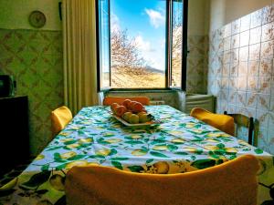 een eettafel met een fruitschaal erop bij le Rose di santina in Mamoiada +48 foto's
