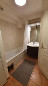 y baño con bañera y lavamanos. en Appartement neuf avec terrasse sur Praloup 1600 en Uvernet