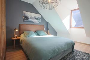 een slaapkamer met een bed met een blauwe muur bij Magnifique T5 Duplex de Grand Standing 120m2 neuf classé 4 étoiles pour 8 personnes en plein centre de Saint-Lary-Soulan in Saint-Lary-Soulan