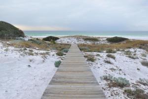 a wooden boardwalk leading to a sandy beach at Sanctuary by the Sea Condos in Santa Rosa Beach