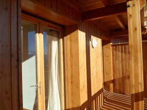 Habitación de madera con ventana y balcón en Appartement neuf avec terrasse sur Praloup 1600 en Uvernet