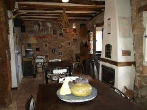 a living room with a table and a fireplace at Albergue el Hacedor in La Aldea del Portillo de Busto