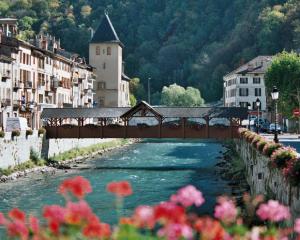 een brug over een rivier in een stad met gebouwen bij Appartement au pied des 3 Vallées in Moutiers