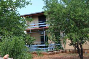 a building with windows and trees in front of it at Hostel Marko in Tisno