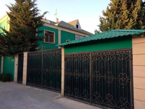 巴庫的住宿－Ansera Badamdar，绿色房子前面的黑色大门