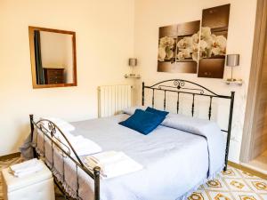 ein Schlafzimmer mit einem Bett mit einem blauen Kissen darauf in der Unterkunft le Rose di santina in Mamoiada