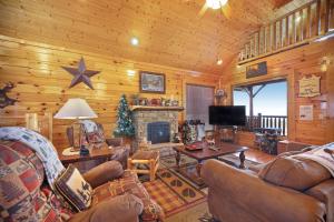 ein Wohnzimmer mit Sofas und einem Kamin in einer Hütte in der Unterkunft 100 Mile View in Pigeon Forge