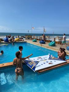 een groep mensen in een zwembad bij The Point Mancora - Beach Party Hostel in Máncora