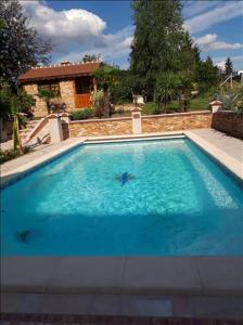 a large blue swimming pool in front of a house at Montevrain Cottage in Montévrain