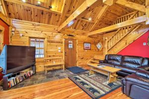 a living room with a couch and a tv in a cabin at Ski Lodge Mtn Retreat with Fire Pit, Deck and Views! in Starksboro