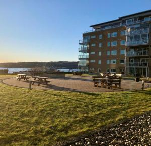 a group of picnic tables in front of a building at Sjønær leilighet med gangavstand til strand i Larvik in Larvik