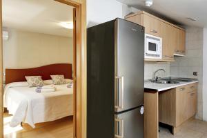 cocina con nevera y dormitorio con cama en Apartamentos Turísticos Centro, en Granada