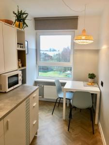 a kitchen with a table and chairs and a window at ROOM 10 in Valmiera