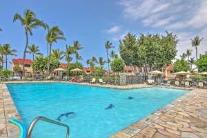 a pool at a resort with dolphins in the water at Ultimate Oceanfront Townhome with AandC On Kona Coast in Kailua-Kona