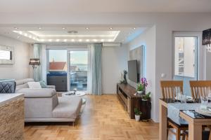 un soggiorno con divano e tavolo di Luxury apartman SKY with sea view and whirlpool a Makarska