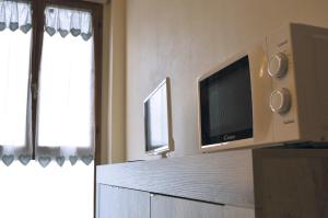 A casa di Lisa in Cisanello في بيزا: مطبخ مع تلفزيون بشاشة مسطحة على الحائط
